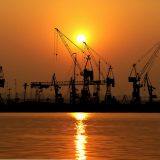 尤果网实测团队成员在双屏工位前记录页面加载耗时，屏幕显示栏目结构图，室内暖光环境
